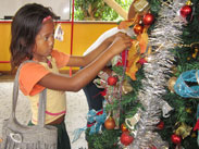 Mädchen schmückt Weihnachtsbaum