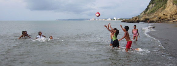 Kinder spielen Ball am Strand